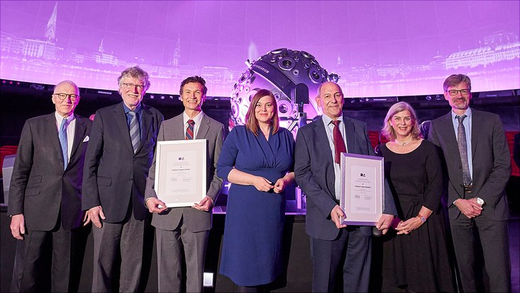 group picture in front of the Hamburg skyline projected on the roof