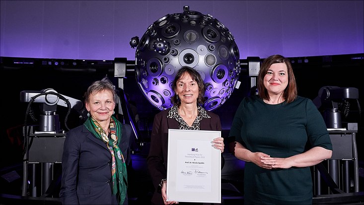 Three women under a dome, behind them astronomic equipment